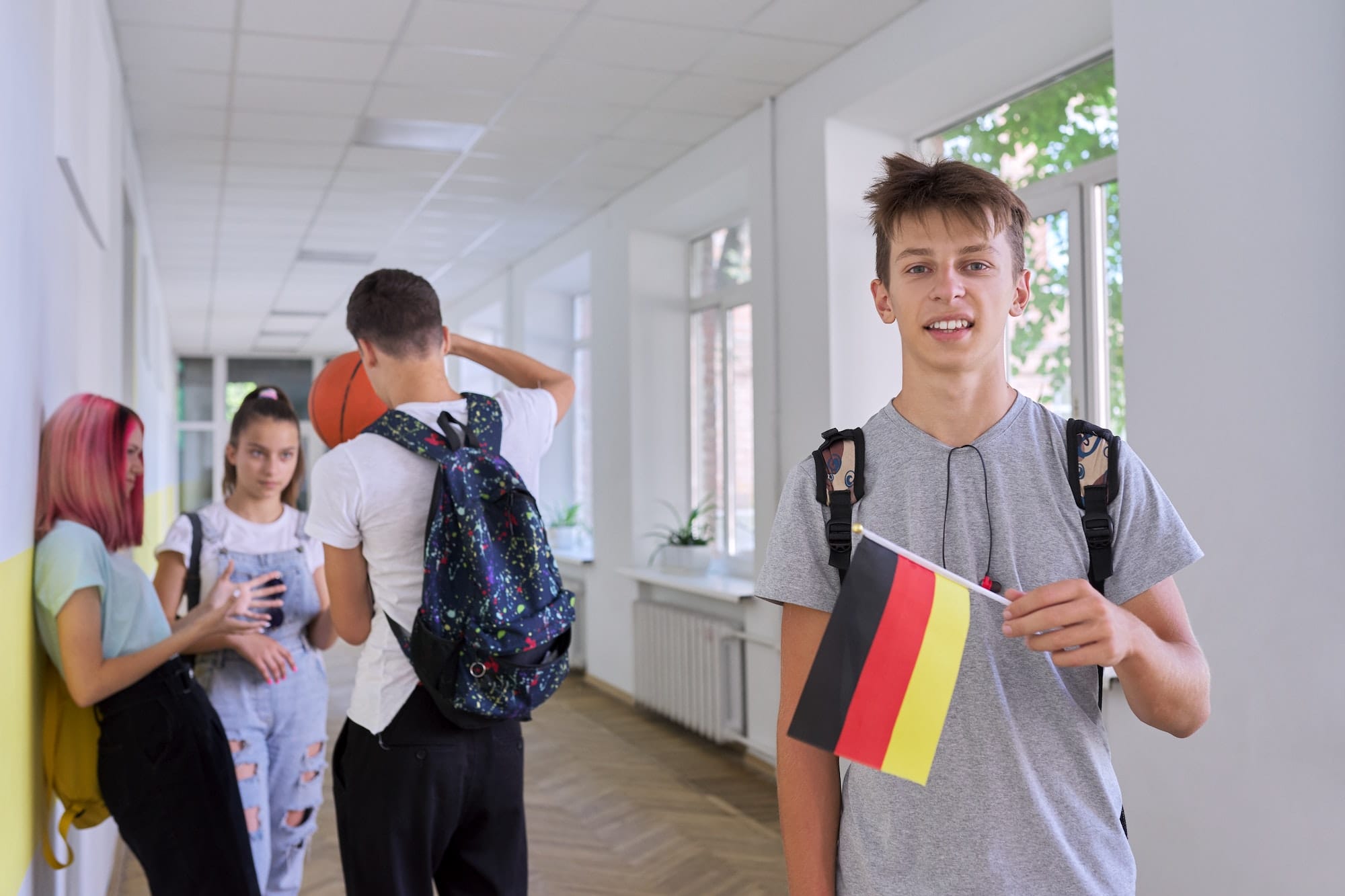 Student teenager male with the flag of Germany inside school, school